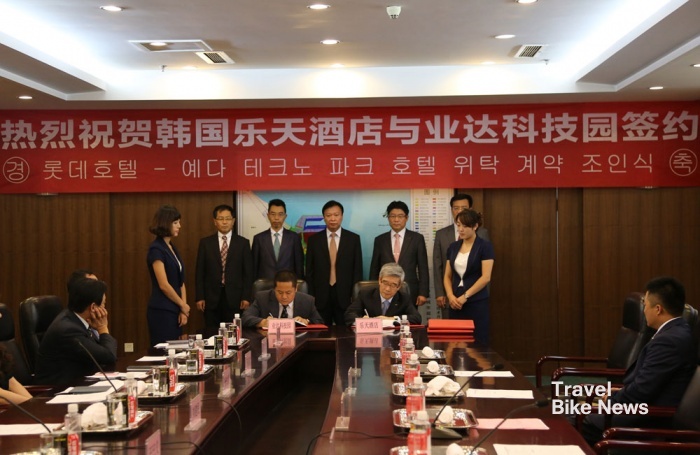 중국 산둥 성 옌타이시 경제개발구청사에서 열린 위탁 계약 조인식에서 롯데호텔 송용덕 대표이사(오른쪽)와 YEDA 테크노파크 이사위 회장(왼쪽)이 조인서에 서명하고 있다(사진제공:롯데호텔).