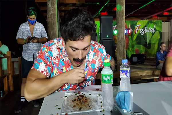 2021년 티니안 핫 페퍼 페스티벌의 핫 페퍼 빨리 먹기 대회 남자 우승자인 리카르도 카라즈코(Ricardo Carrazco)가 도니살리 고추 100개를 먹고 있다. 사진/마리아나관광청