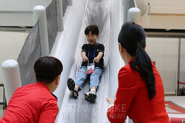 티웨이항공이 가정의 달을 맞아 진행한  't'family day'에서 티웨이항공 임직원 가족들이 B737 항공기 슬라이드 훈련을 체험하고 있다. 사진/티웨이항공